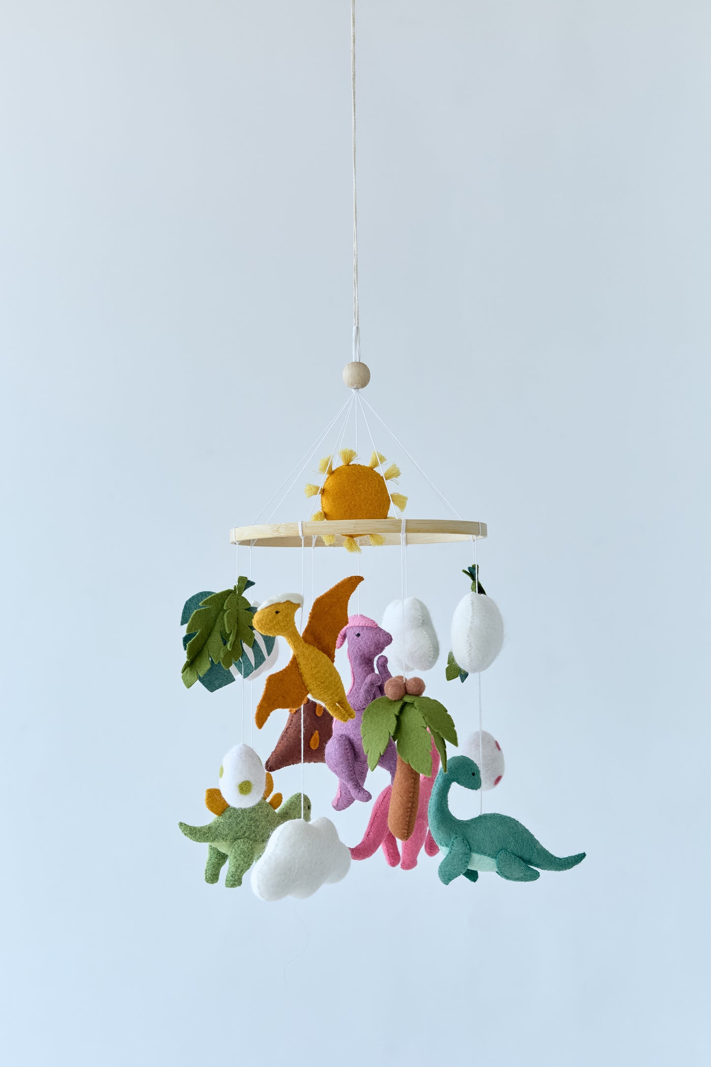 Full view of hanging dinosaur mobile above crib