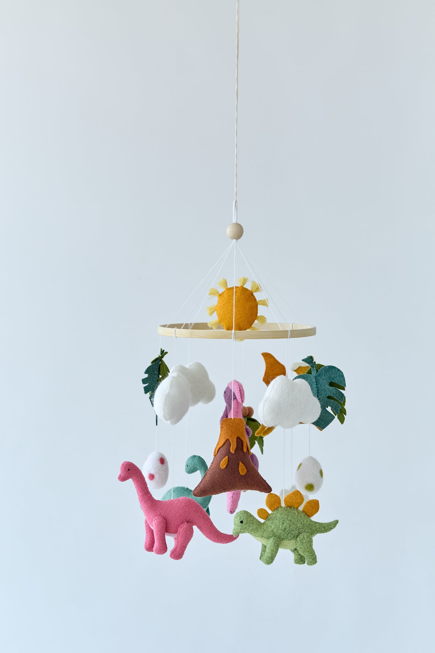 Full view of hanging dinosaur mobile above crib