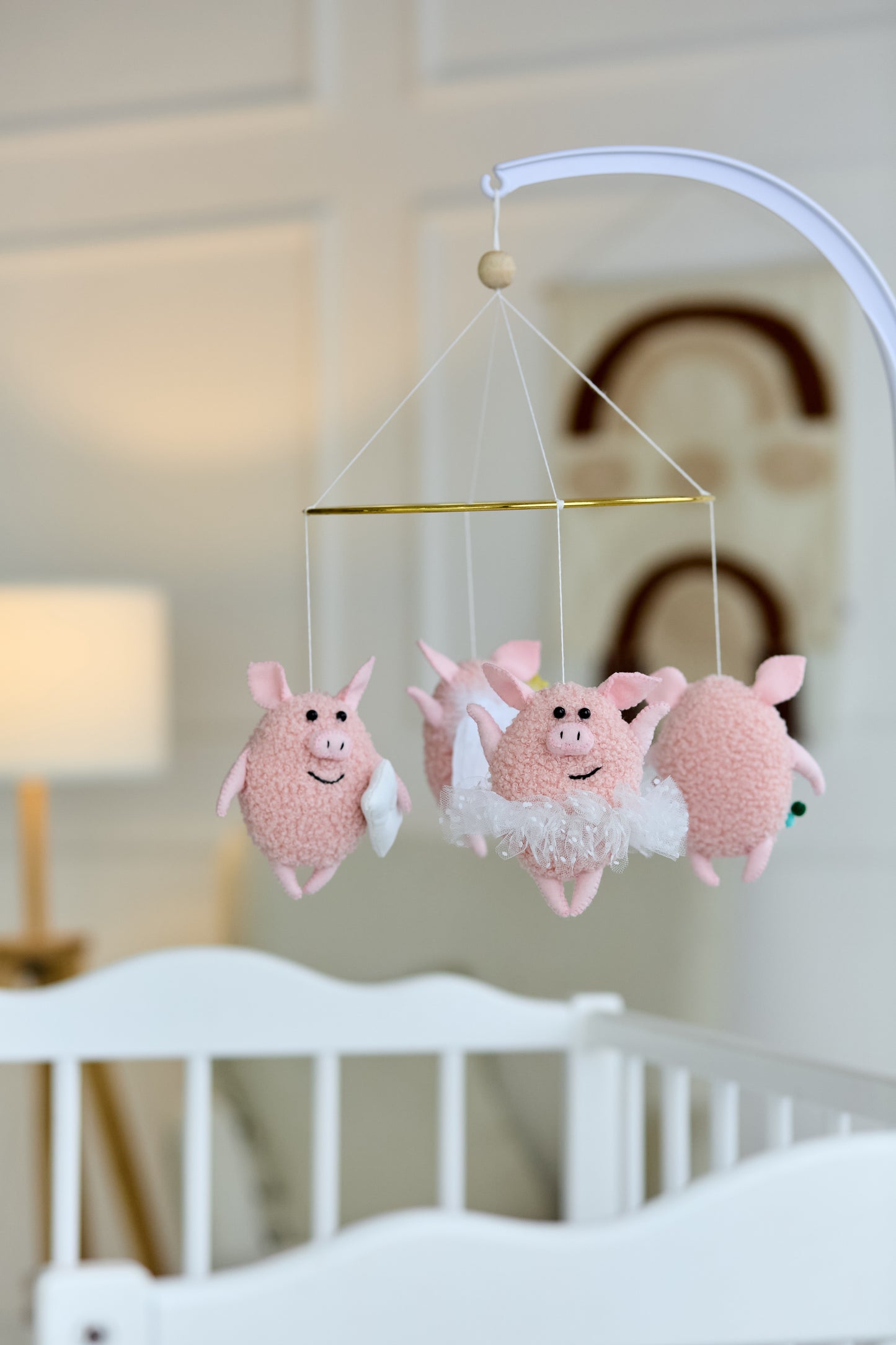 Handmade baby mobile with four pink boucle piglets on metal hoop