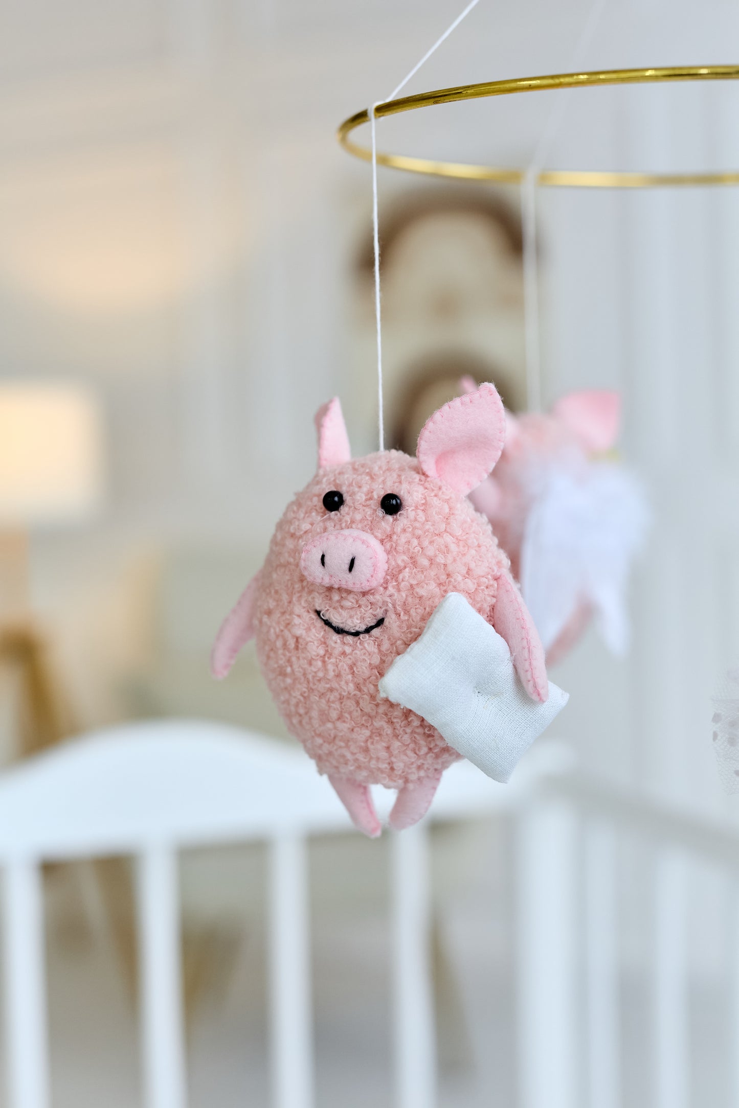 Close-up of a felt piglet from nursery mobile, baby shower decor