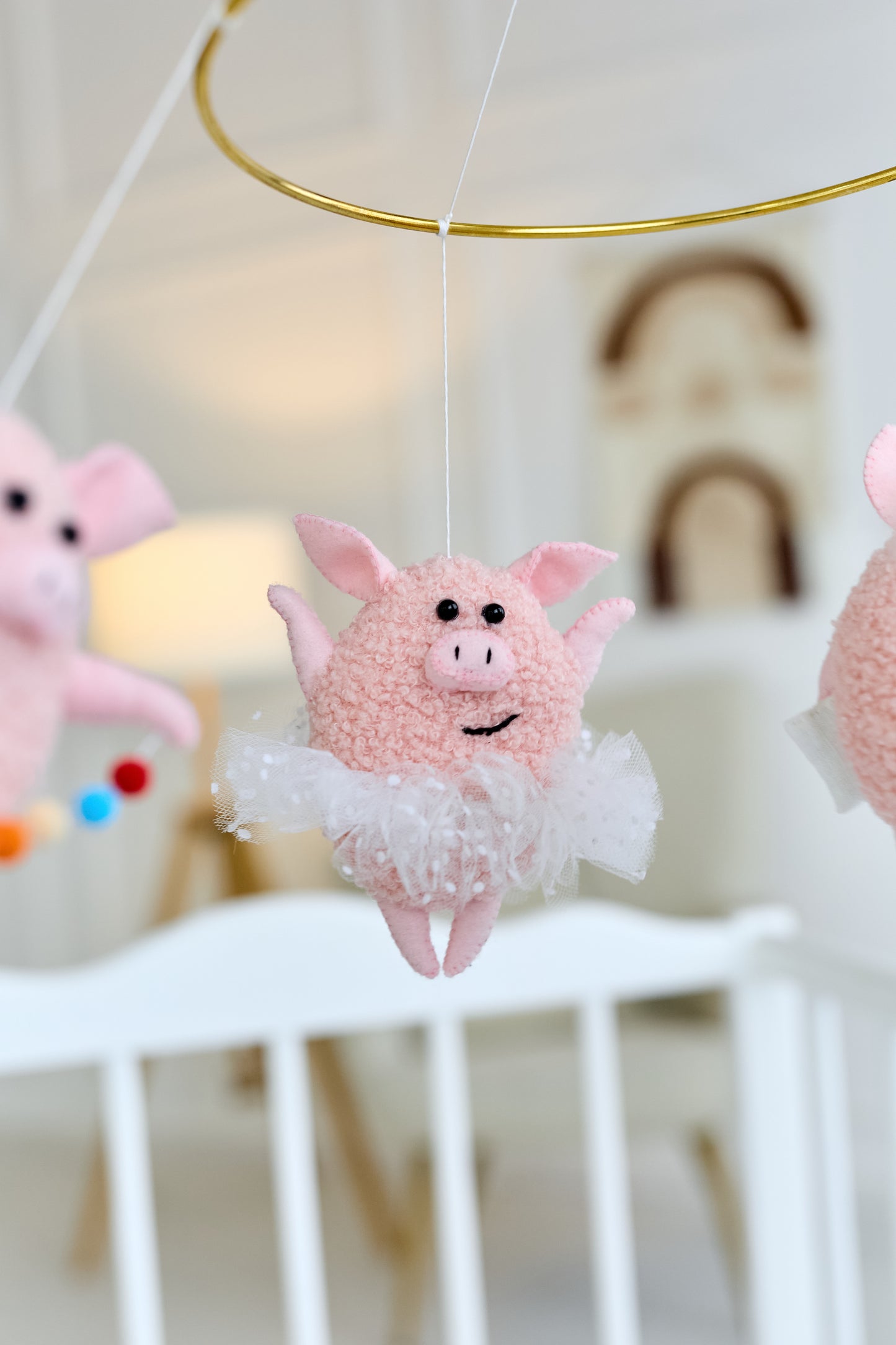 Close-up of a felt piglet from nursery mobile, baby shower decor