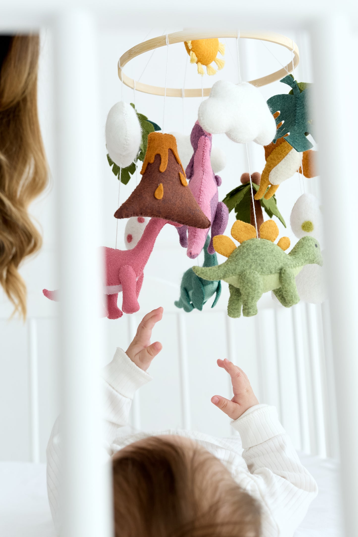 Close-up of felt dinosaurs hanging from wooden hoop