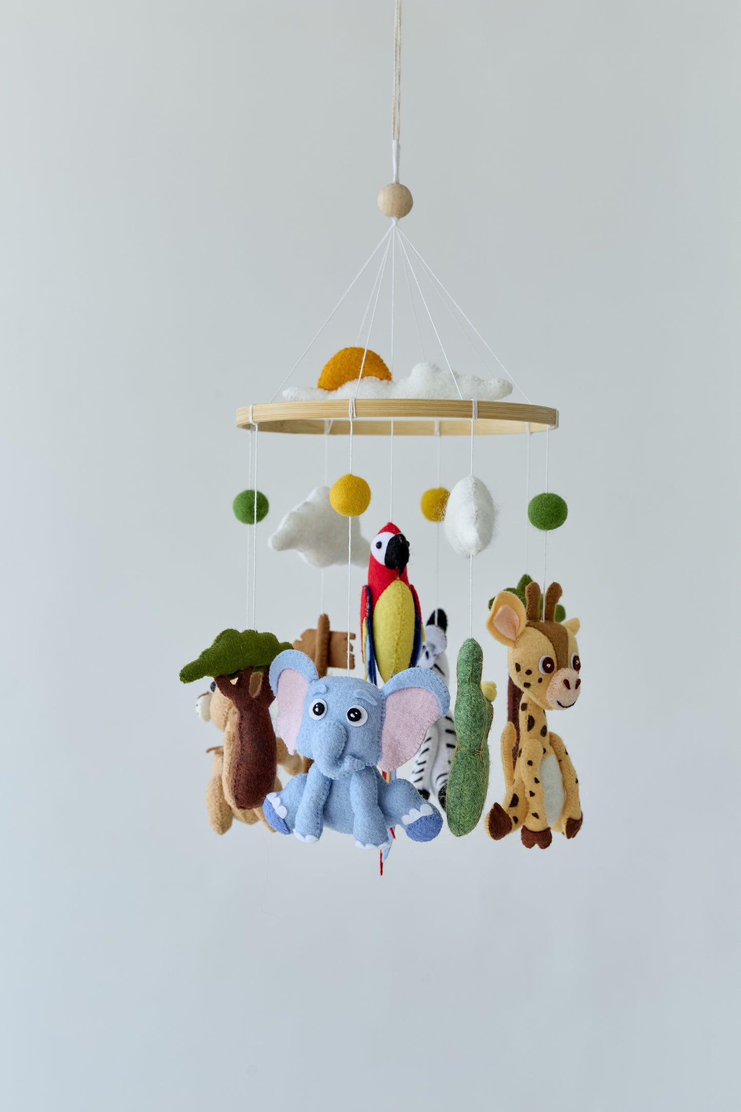 Gender-neutral jungle crib mobile with wool felt balls
