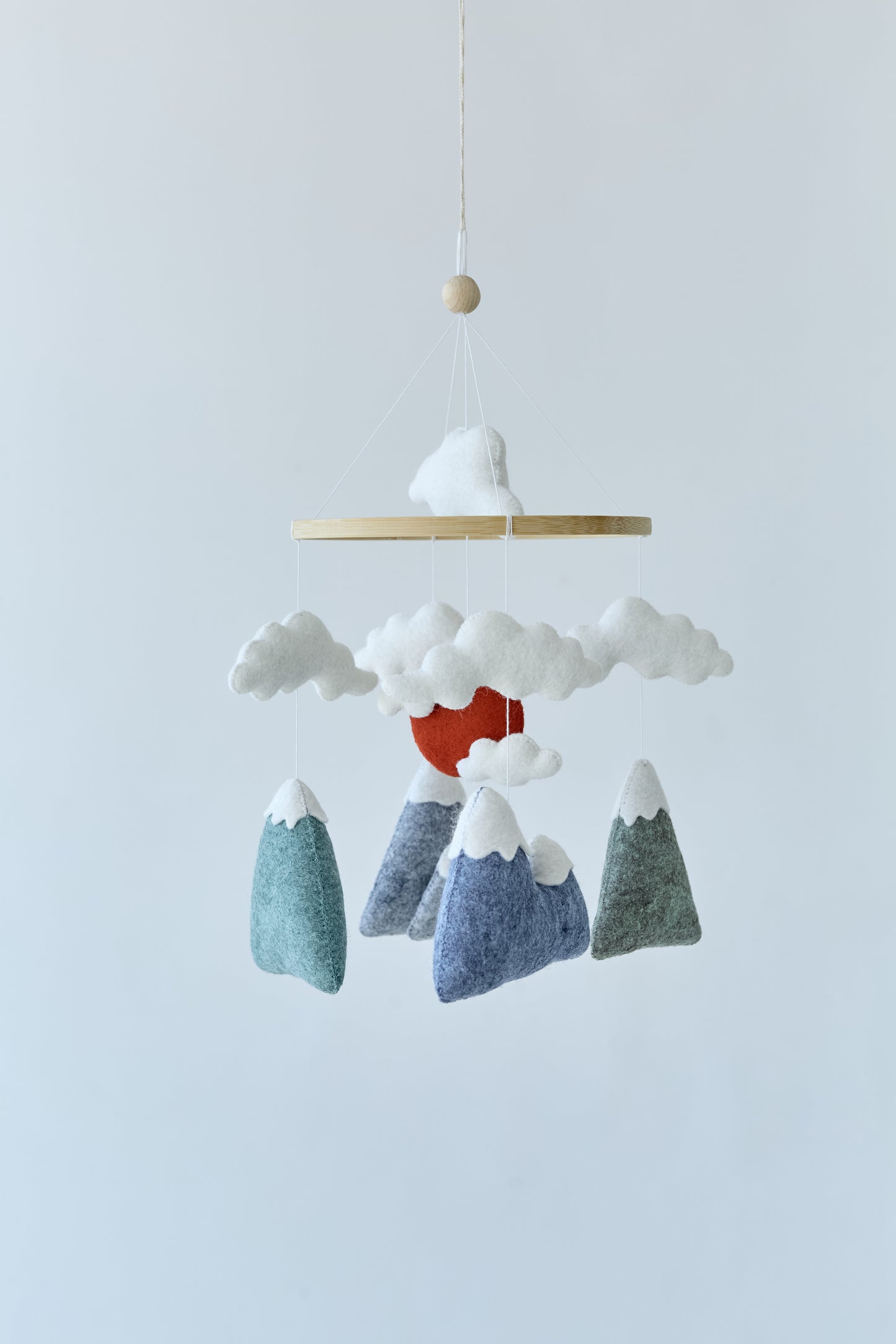Close-up of mountains, clouds, and wool balls in baby mobile
