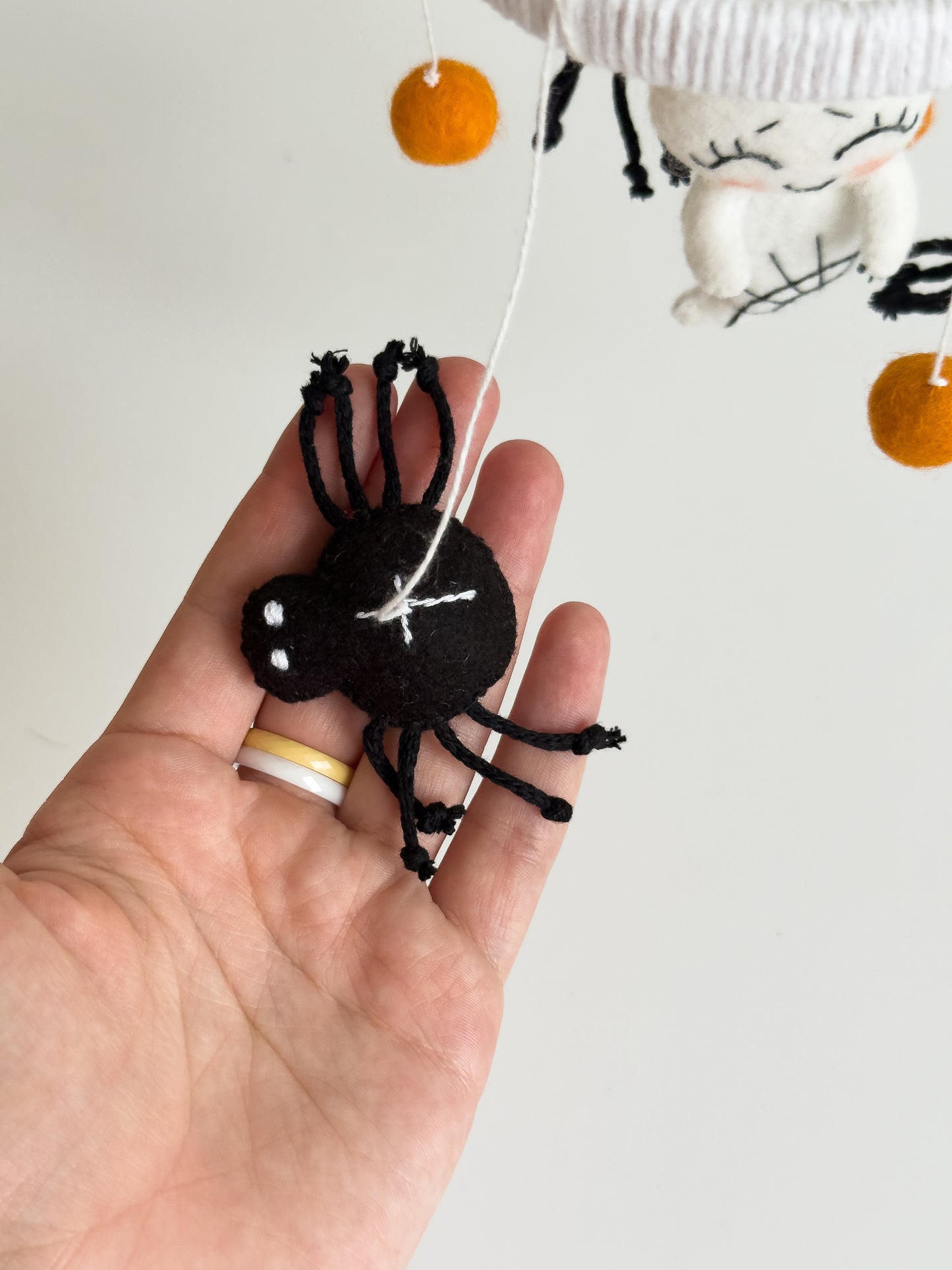 Close-up of spiderweb ring and soft felt spiders