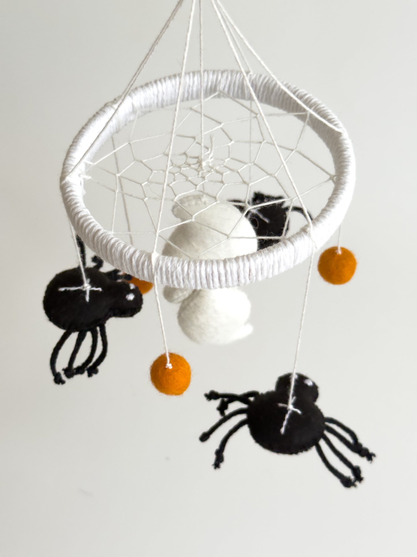 Close-up of spiderweb ring and soft felt spiders