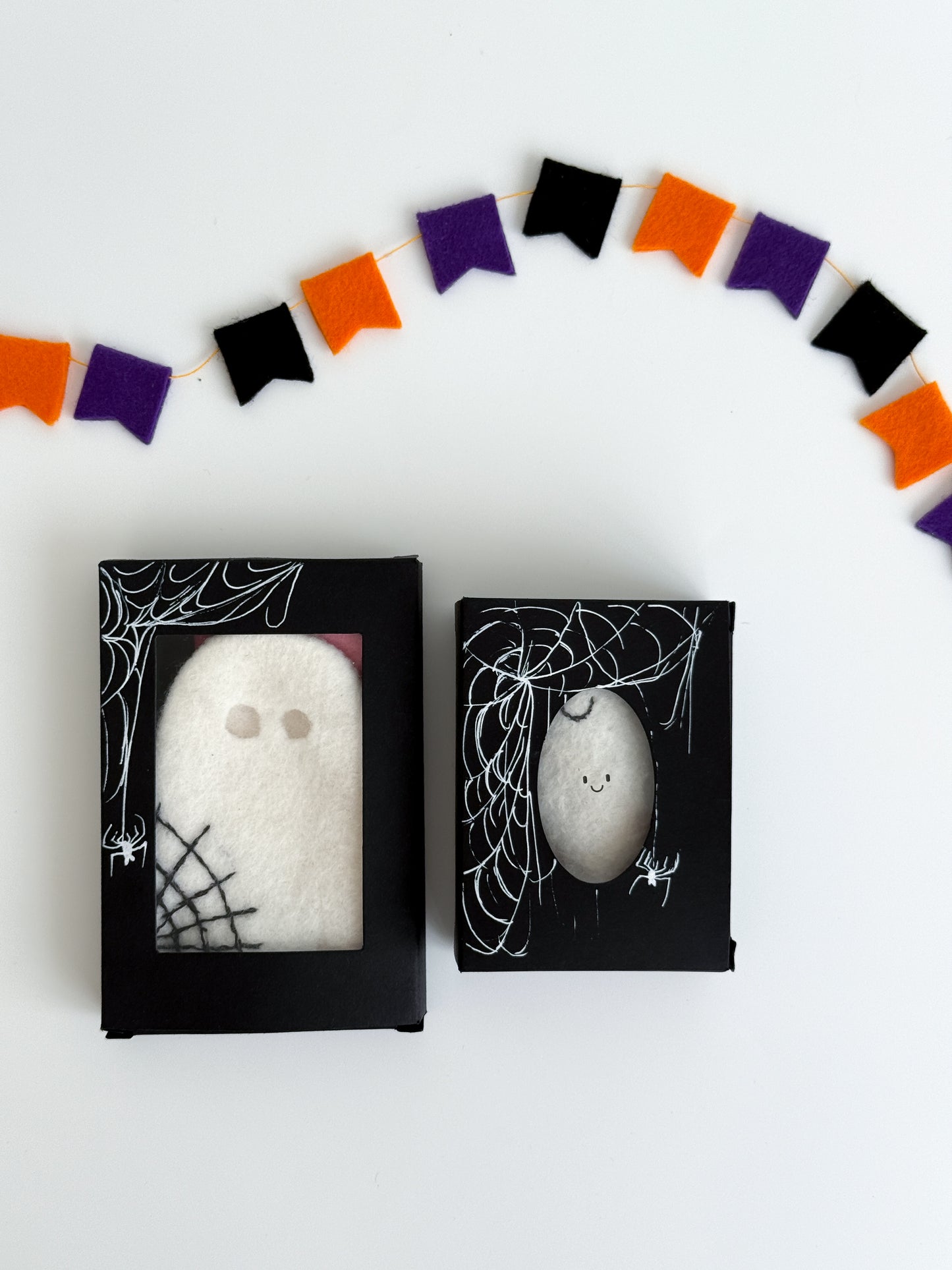 Black Halloween gift box with felt ghost toy inside, decorated with white spiderweb and spider design