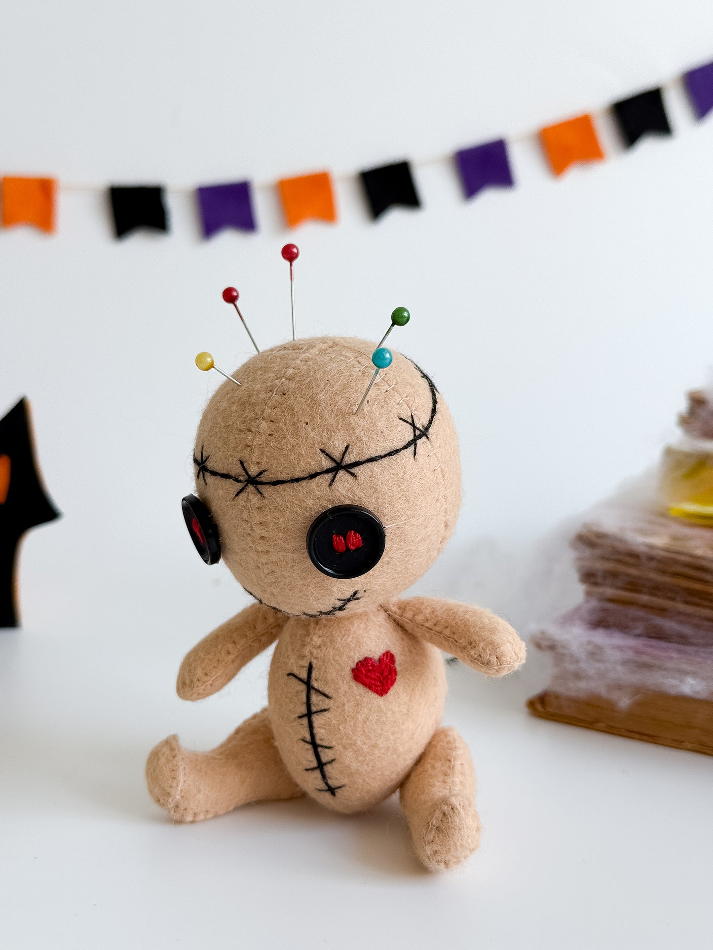Handmade felt voodoo doll with button eyes and stitched heart