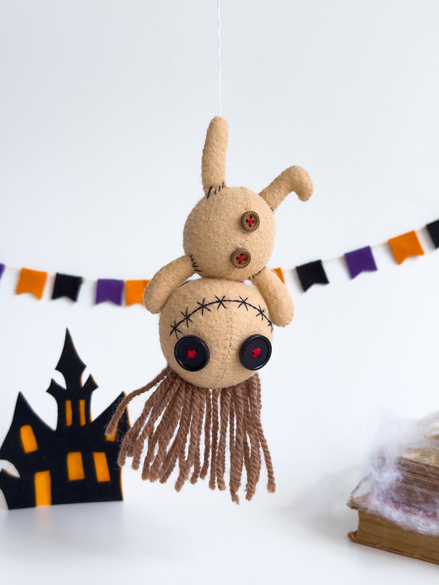 Beige voodoo doll plush hanging by ear