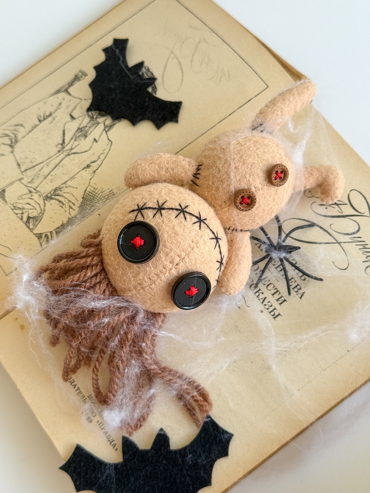 Beige voodoo doll plush hanging by ear