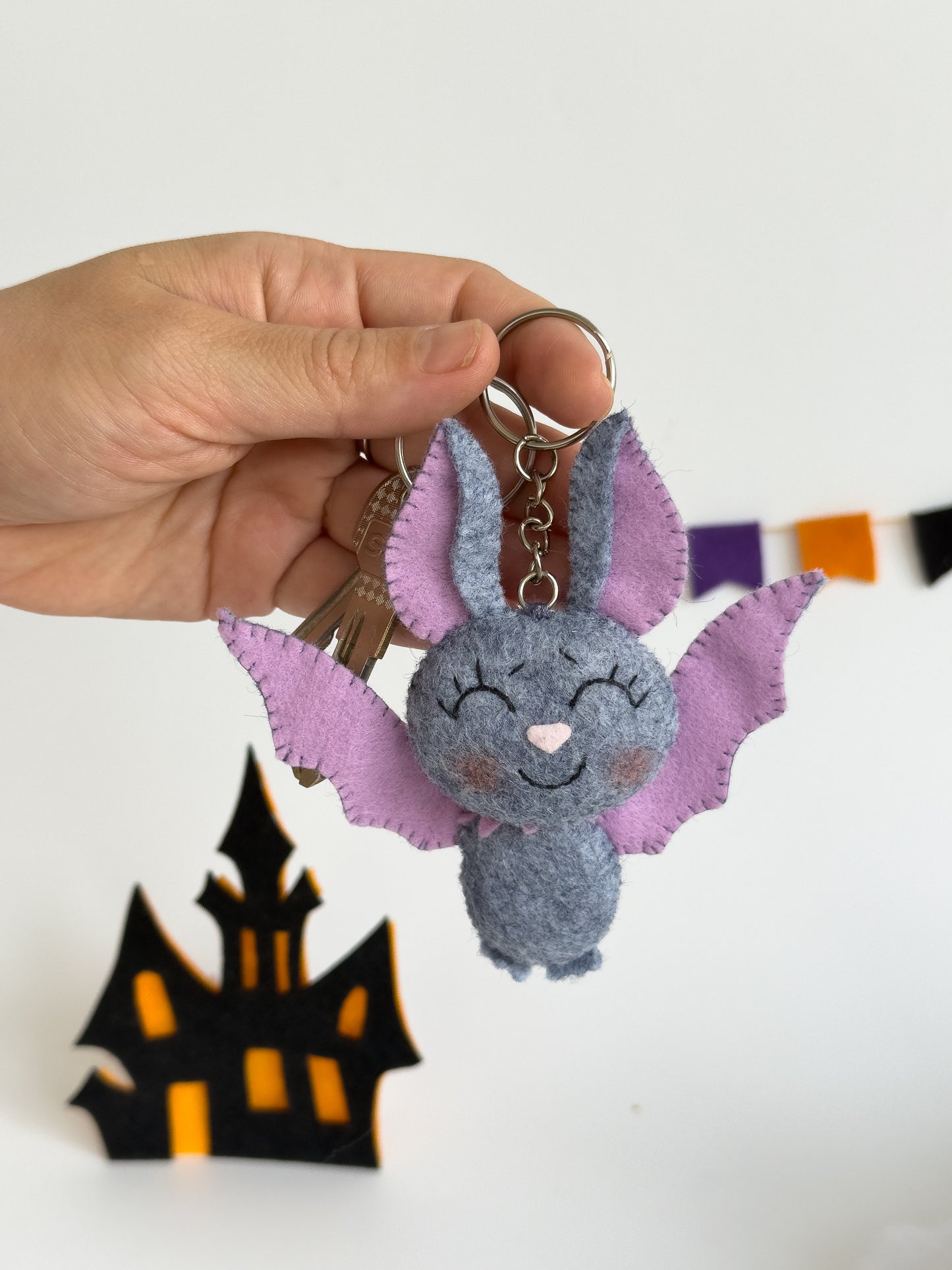 Handmade felt bat keychain with lavender wings and smiling face, perfect cute Halloween accessory