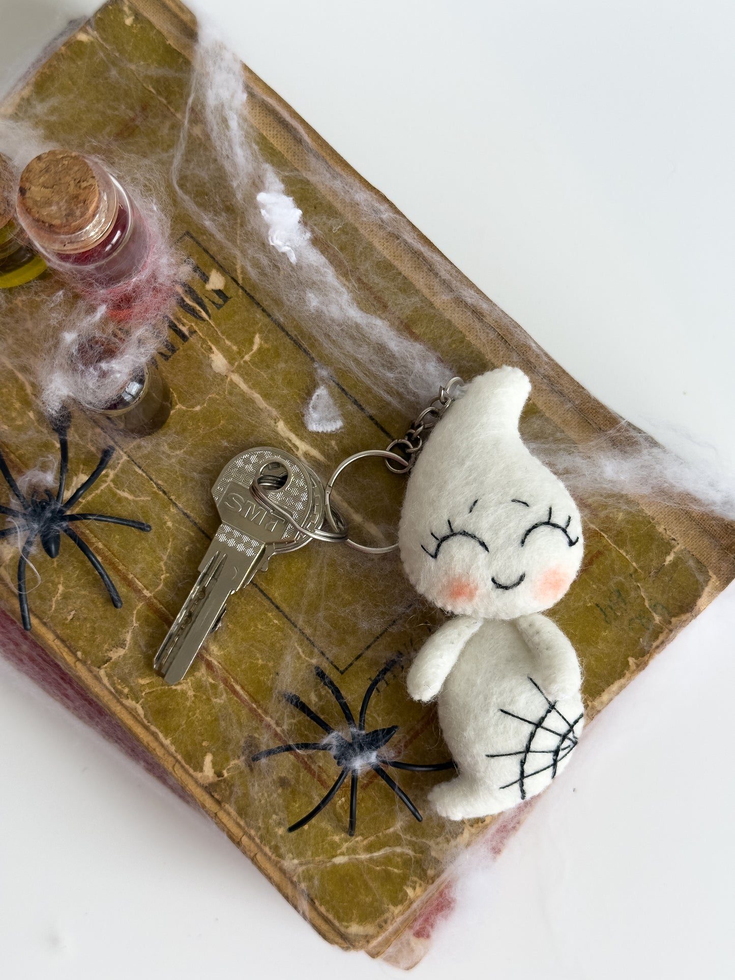 Ghost keychain in hand with keys attached