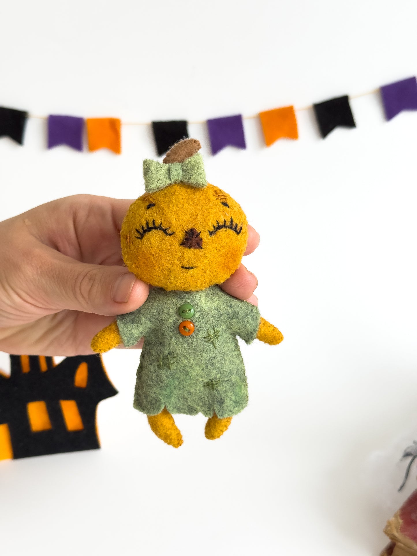 Plush pumpkin girl doll made of soft felt for spooky nursery theme