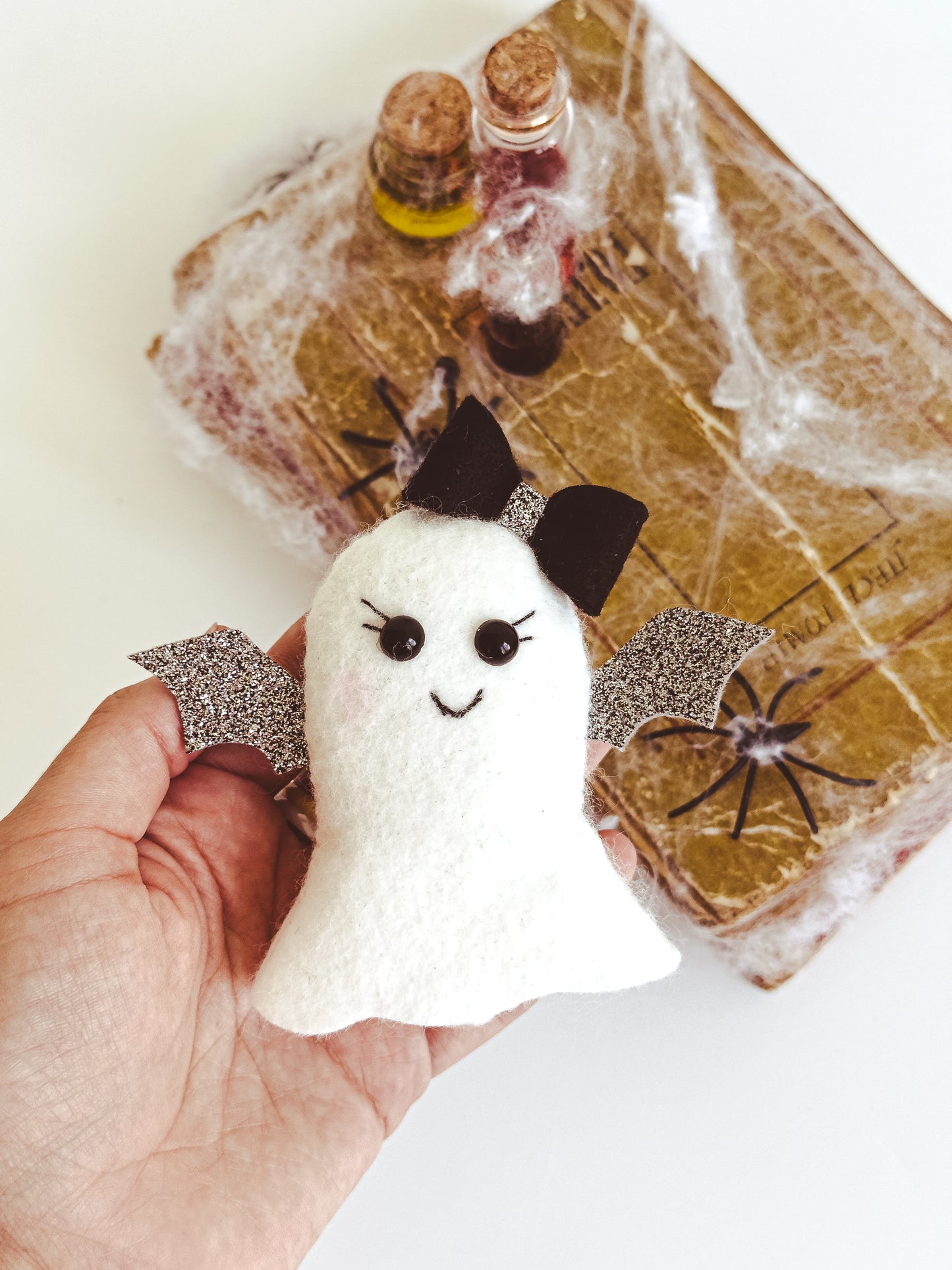 Handmade felt ghost ornament with silver glitter wings and bow