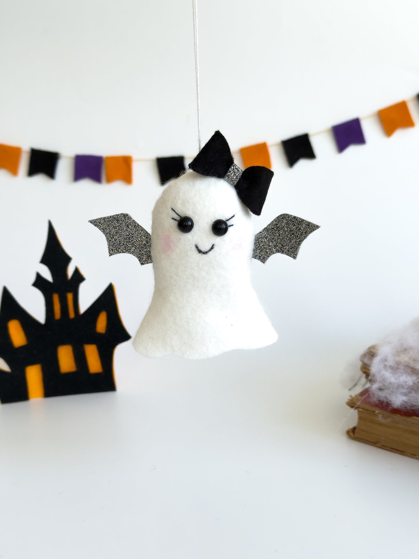 Felt ghost ornament with bat wings and black bow, 4 inches tall