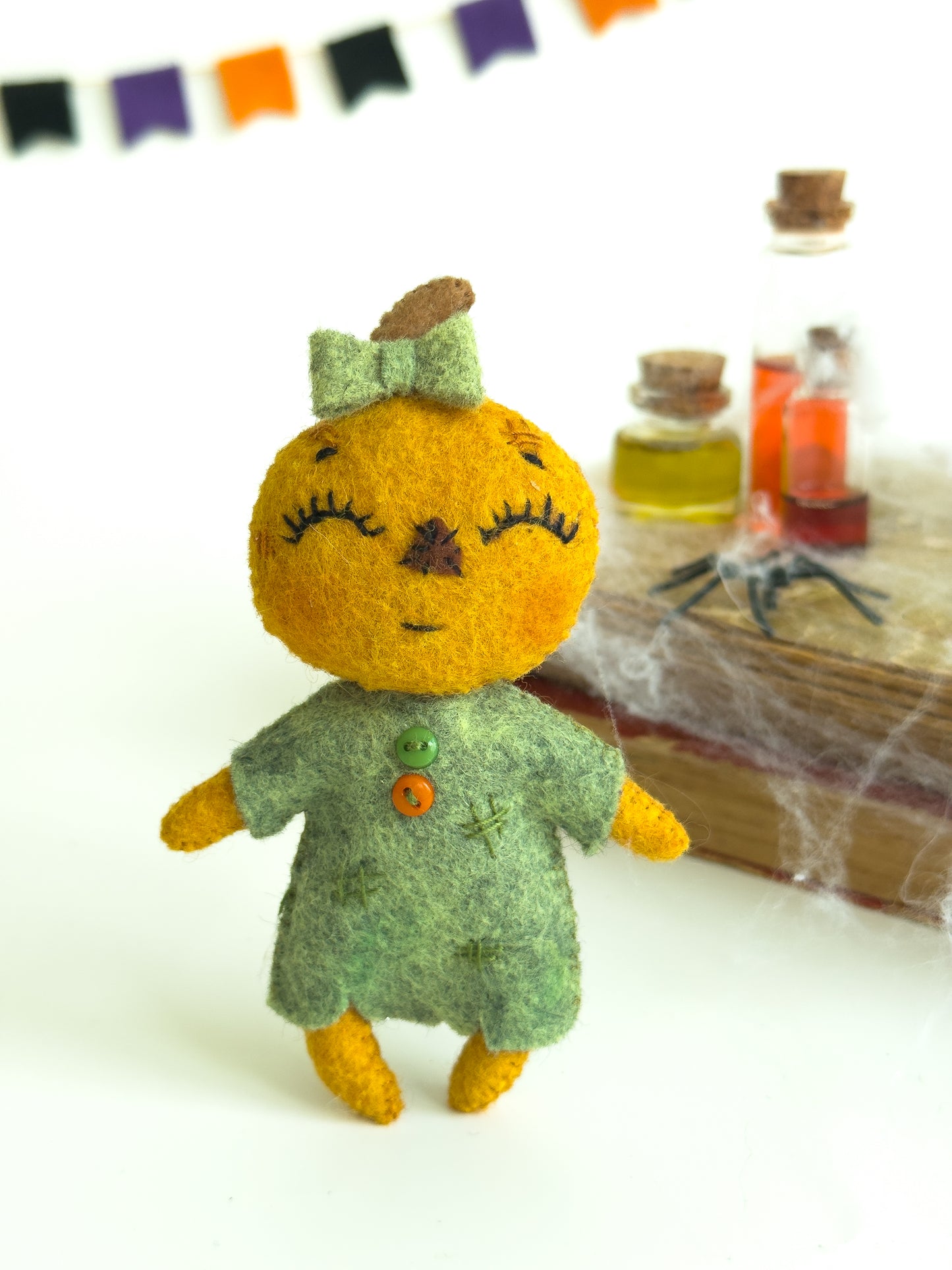 Plush pumpkin girl doll made of soft felt for spooky nursery theme