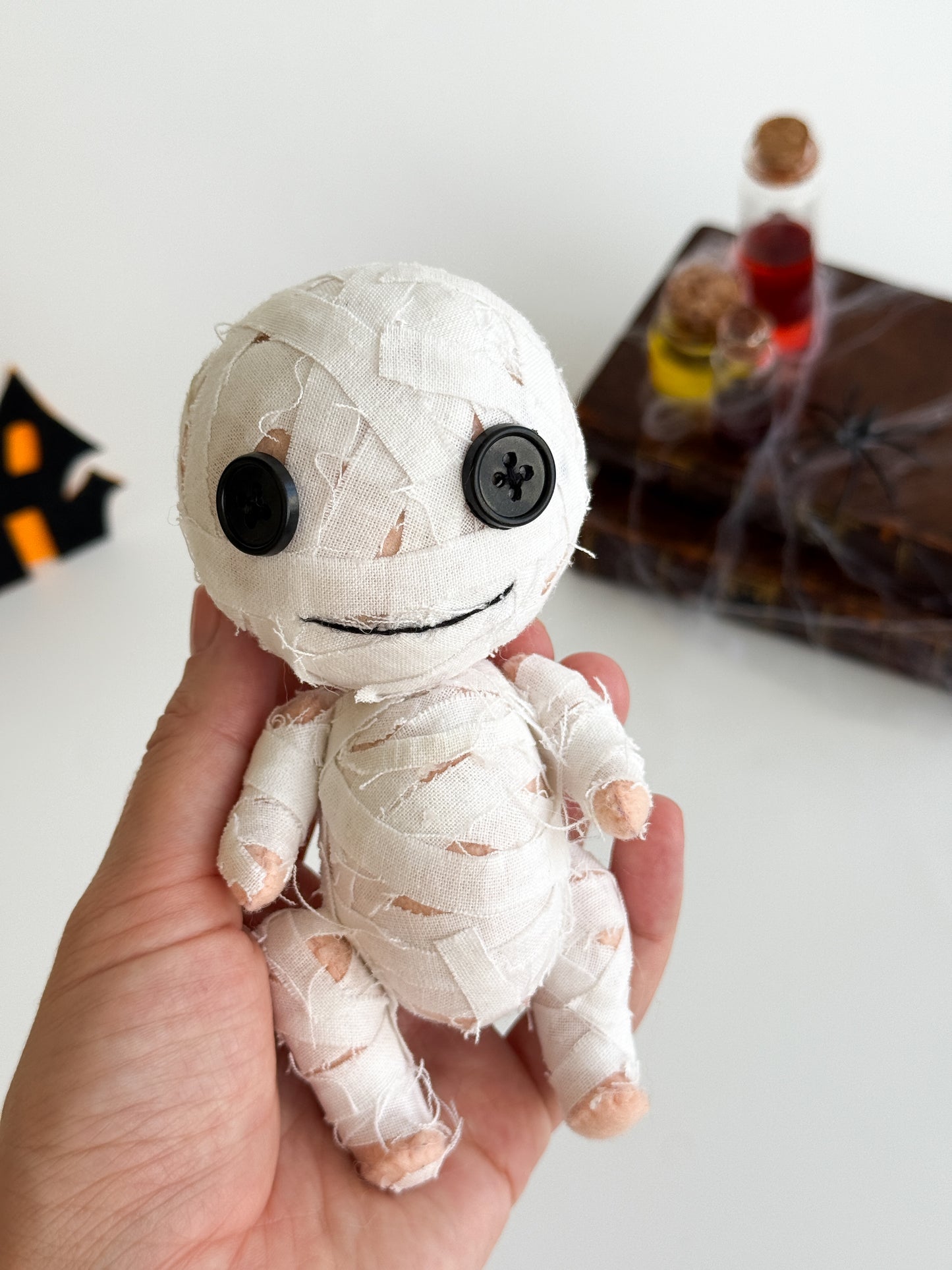 Cute white mummy Halloween plush toy held in hand