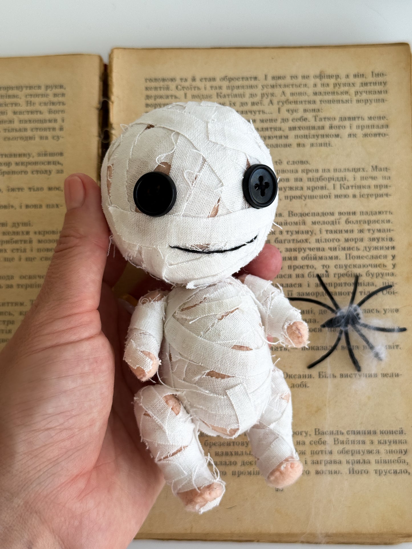Cute white mummy Halloween plush toy held in hand