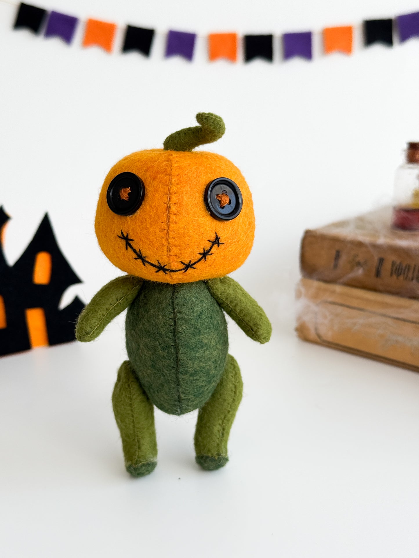 Halloween soft toy with stitched face and curly stem
