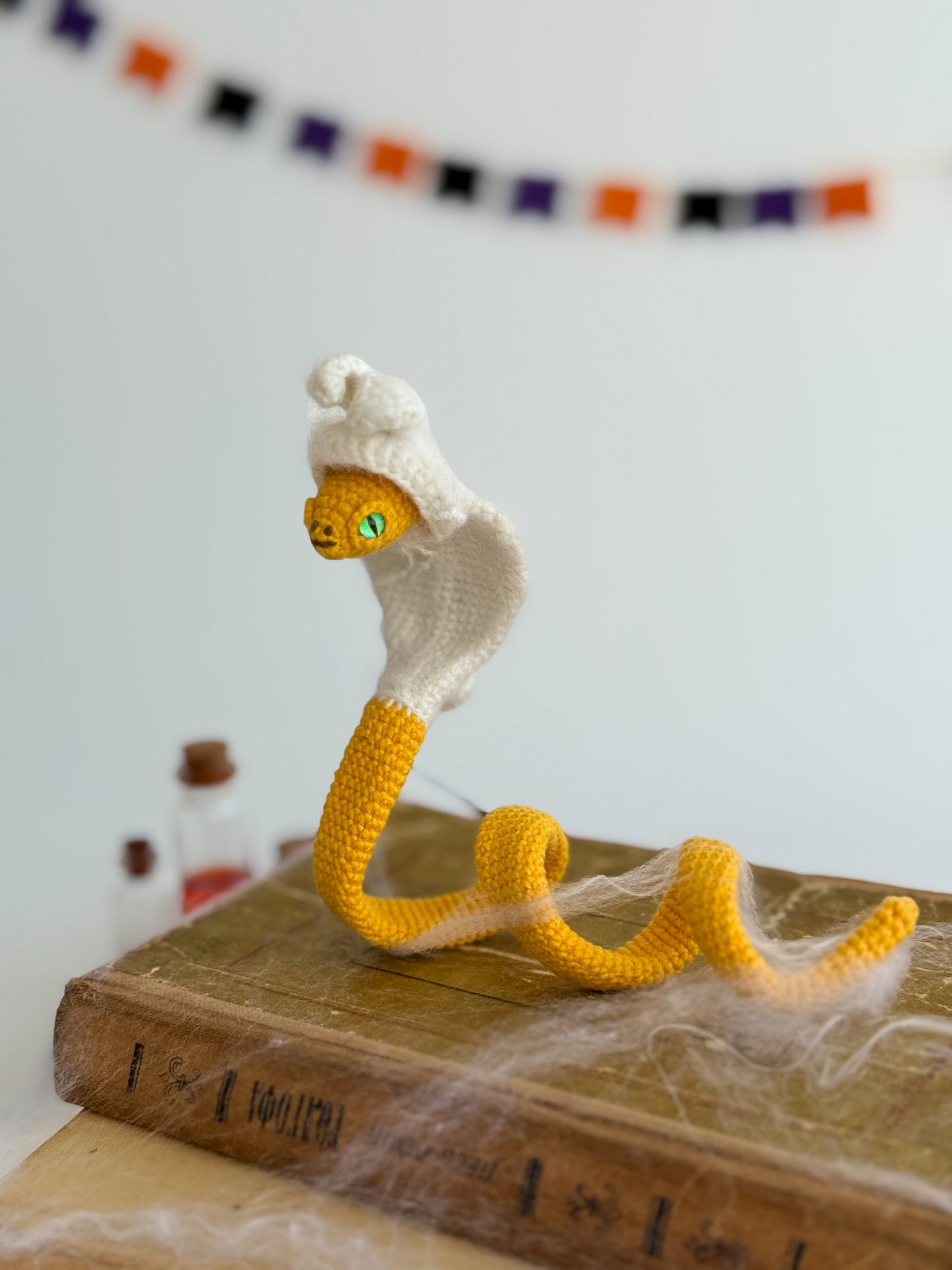 Poseable crochet snake in hoodie, soft handmade plush for collectors and gifts.