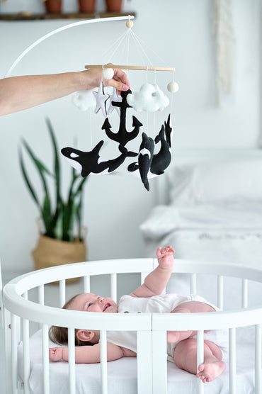 Monochrome orca mobile hanging over crib – handmade felt toy