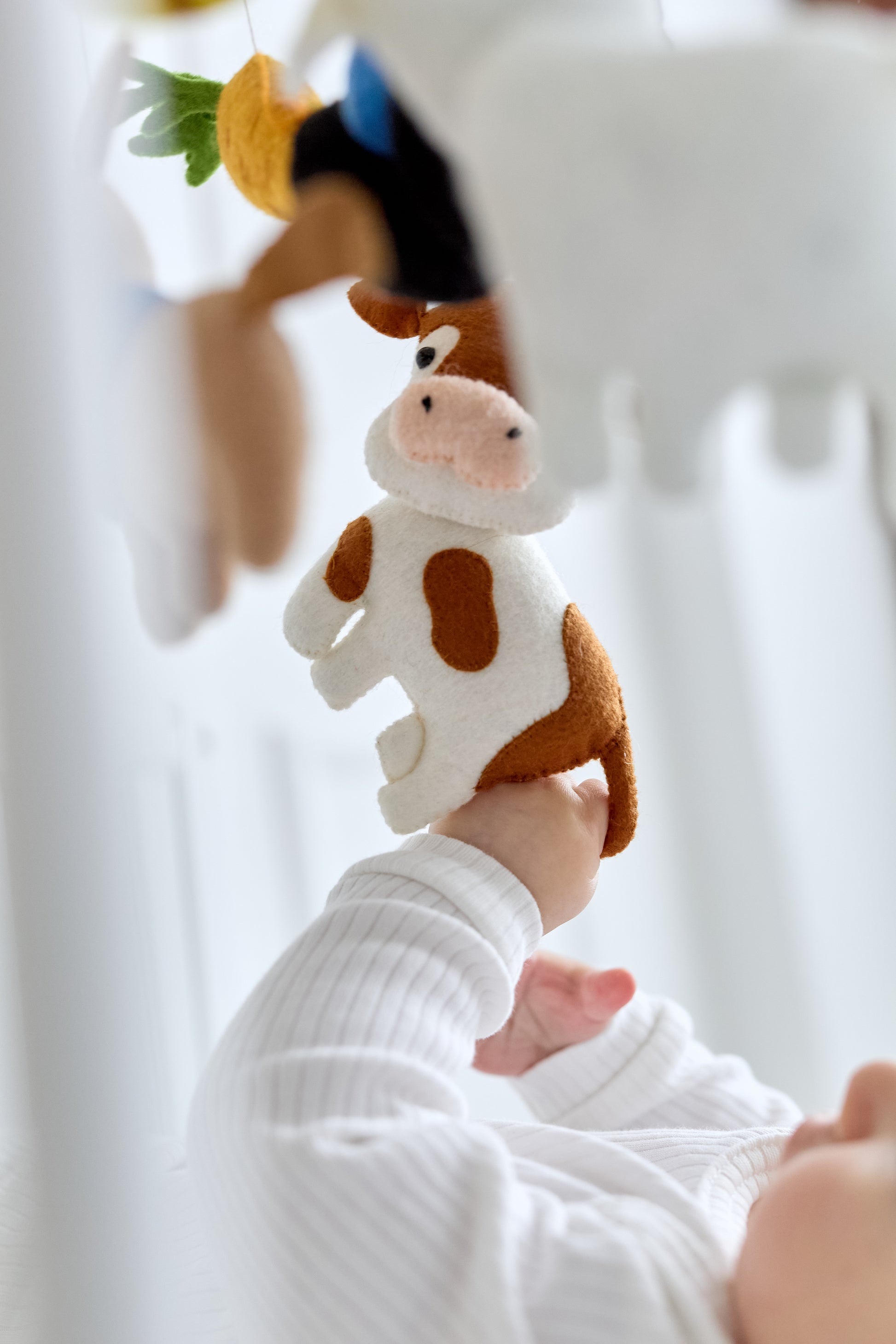 Close-up of felt cow and goat on nursery mobile