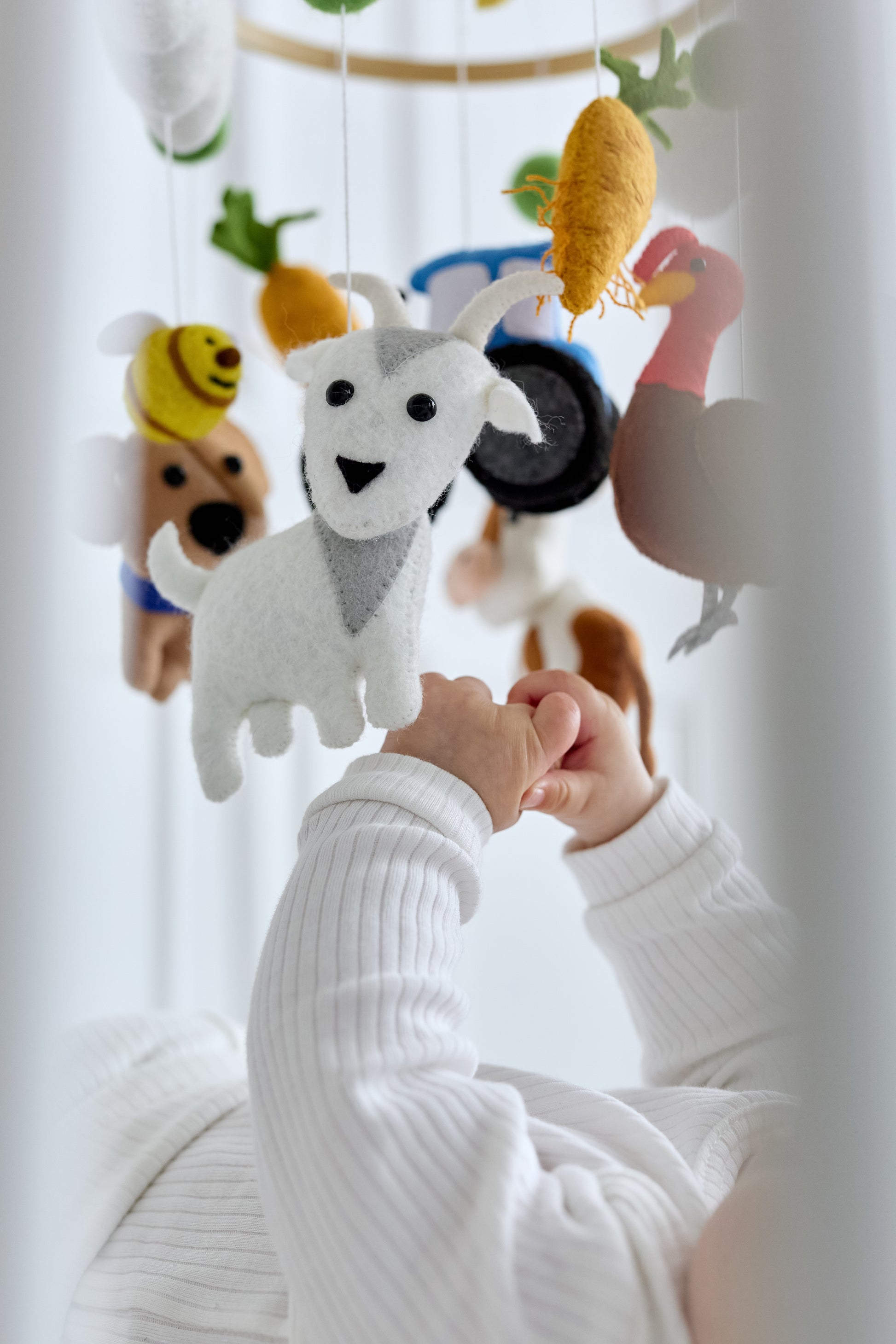 Soft felt figures on handmade baby mobile for crib