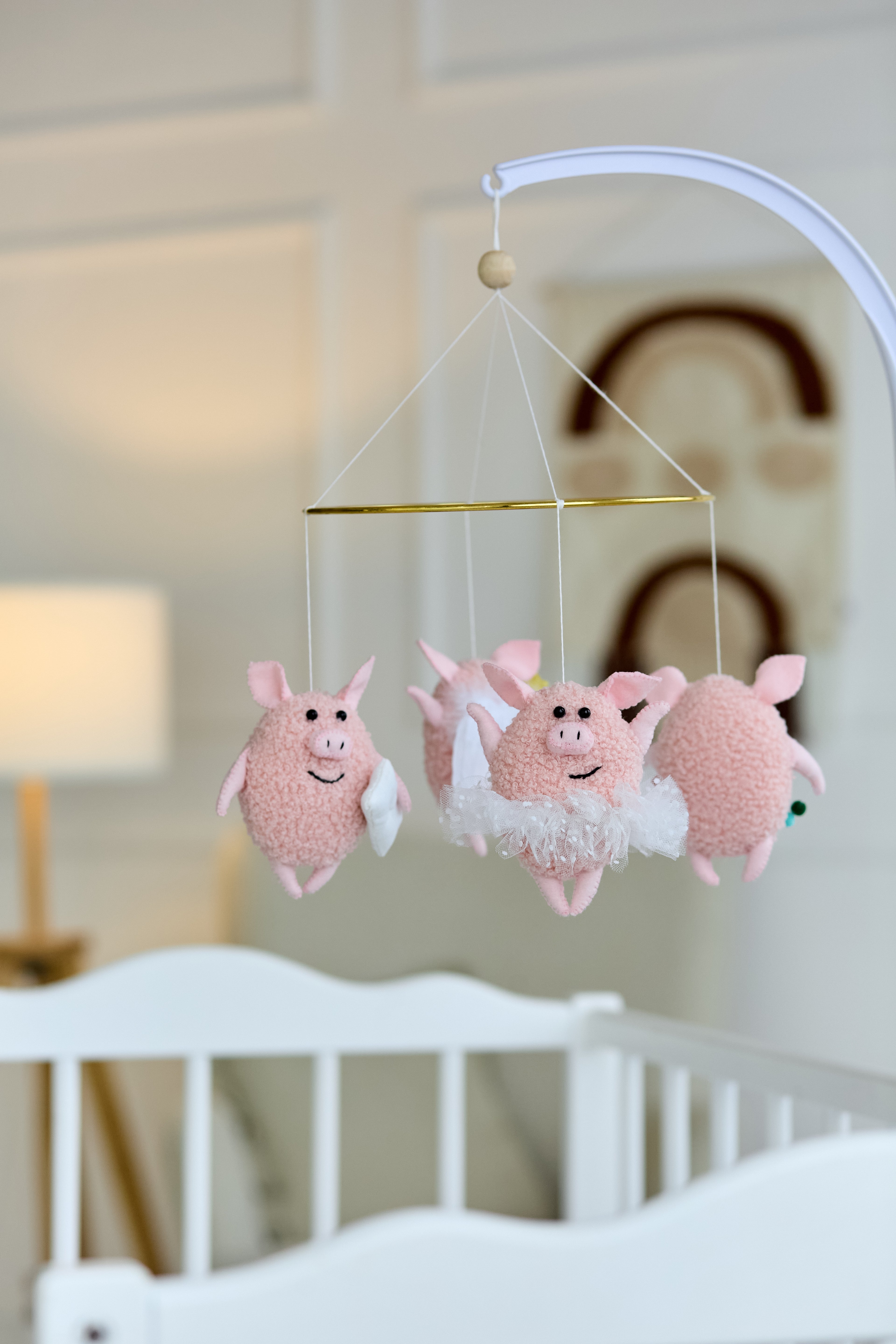 Handmade baby mobile with four pink boucle piglets on metal hoop