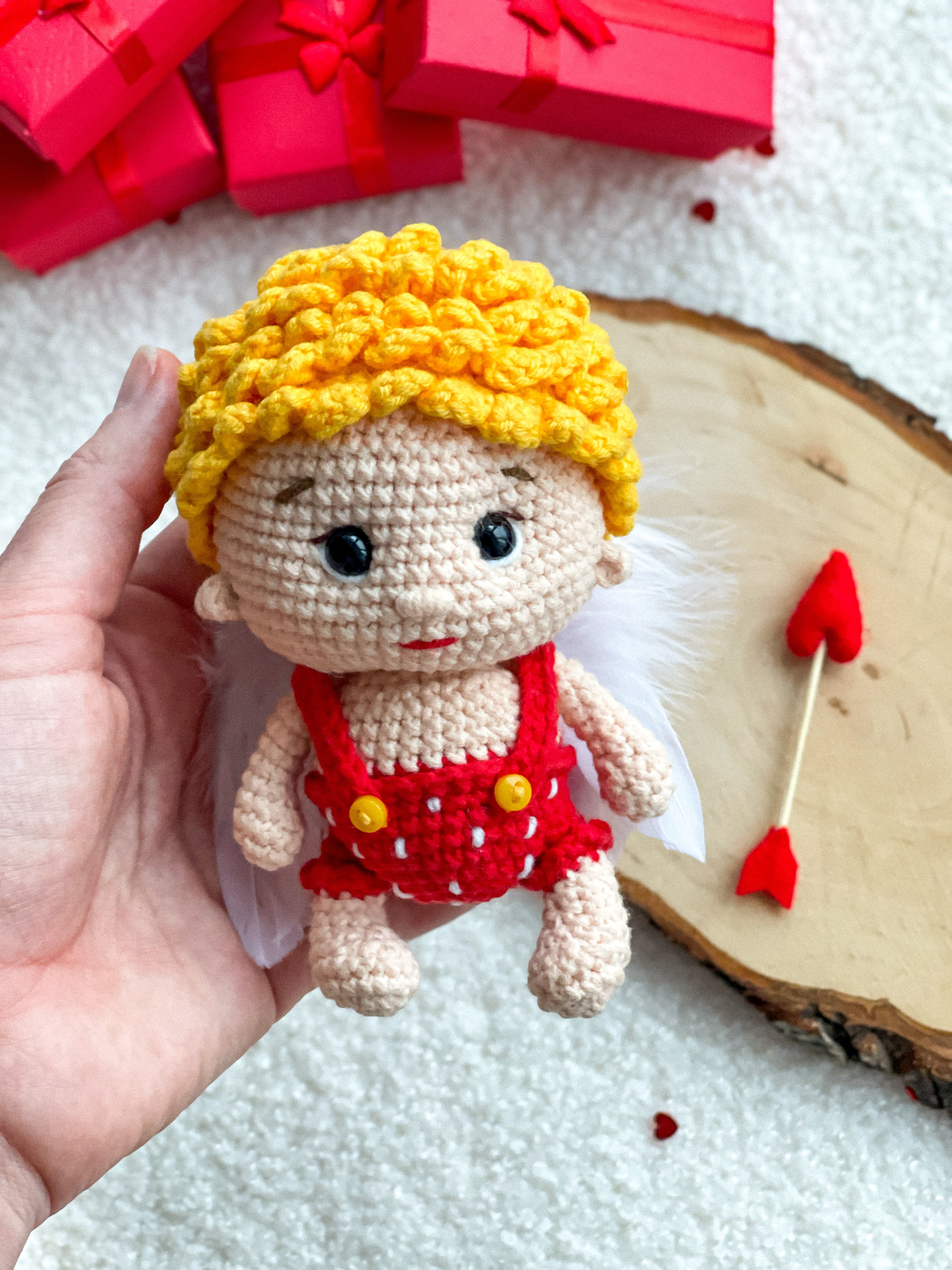 Handmade crochet Cupid with feather wings holding arrow