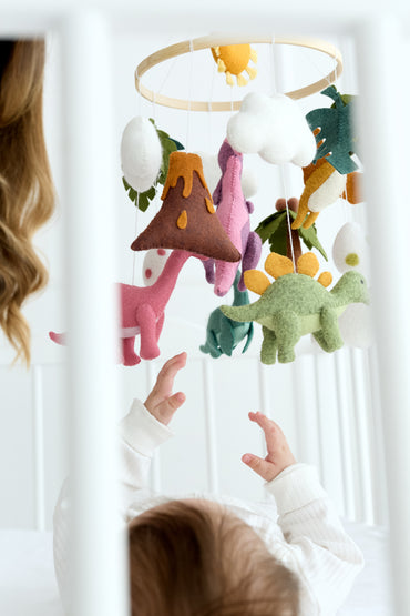 Close-up of felt dinosaurs hanging from wooden hoop