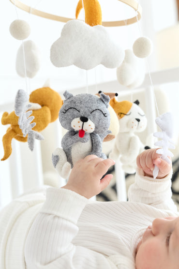 Handmade nursery mobile with wool balls and cat toys