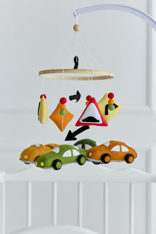 Felt car baby mobile with traffic signs hanging over crib