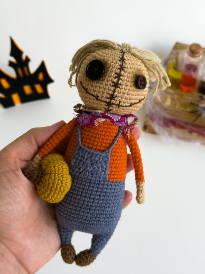 Handmade crochet scarecrow with mini pumpkin and straw hat


