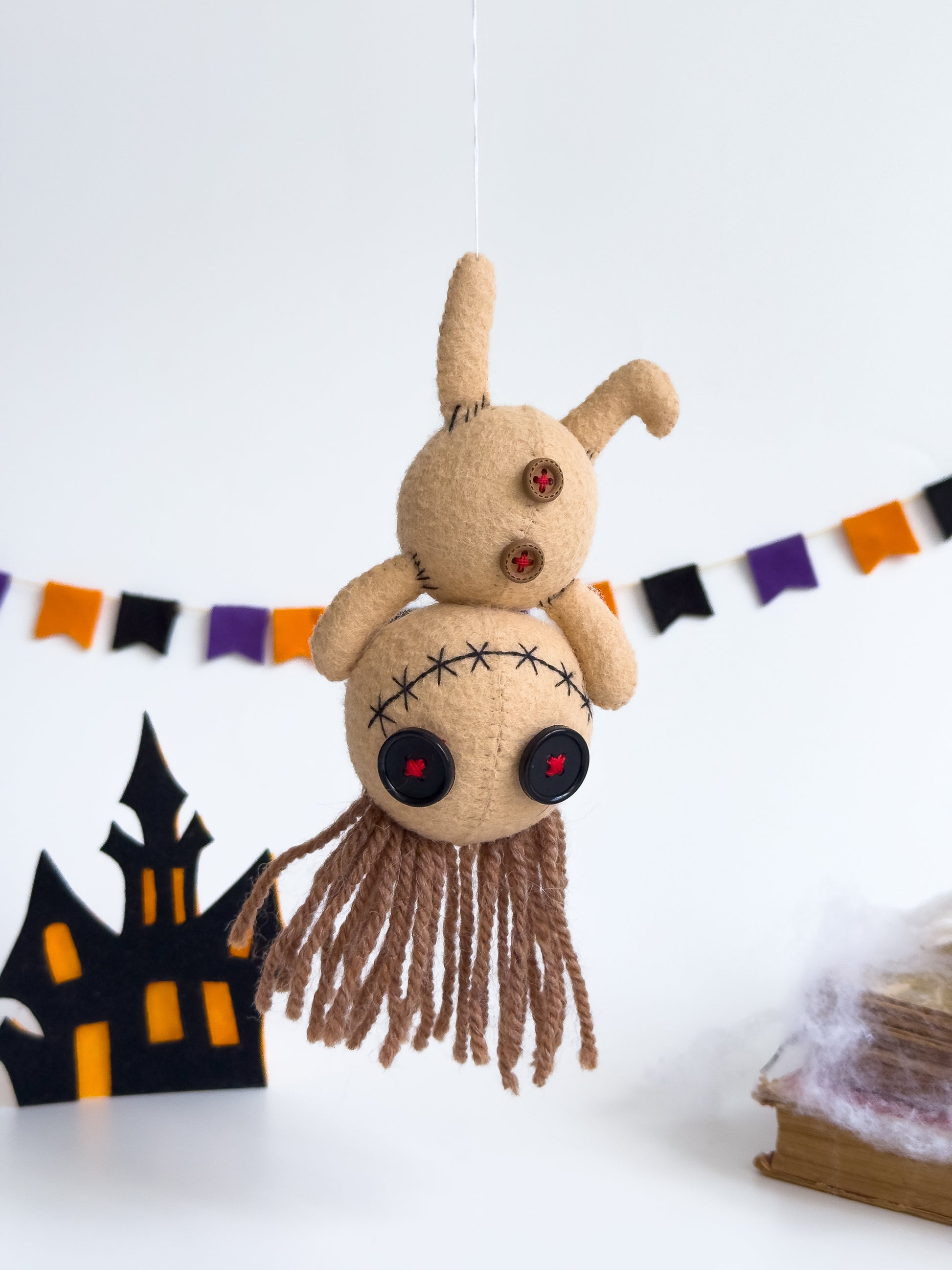 Beige voodoo doll plush hanging by ear