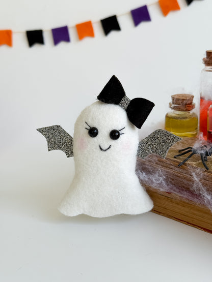 Spooky cute ghost plush ornament on Halloween-themed background