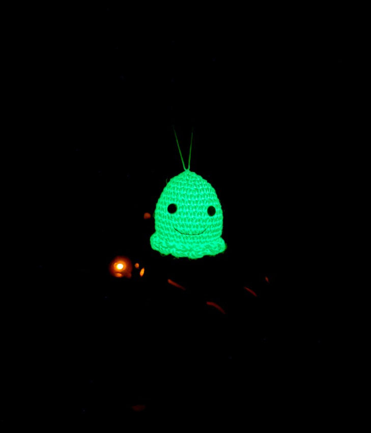 Glow in the dark crochet ghost ornament hanging on rearview mirror